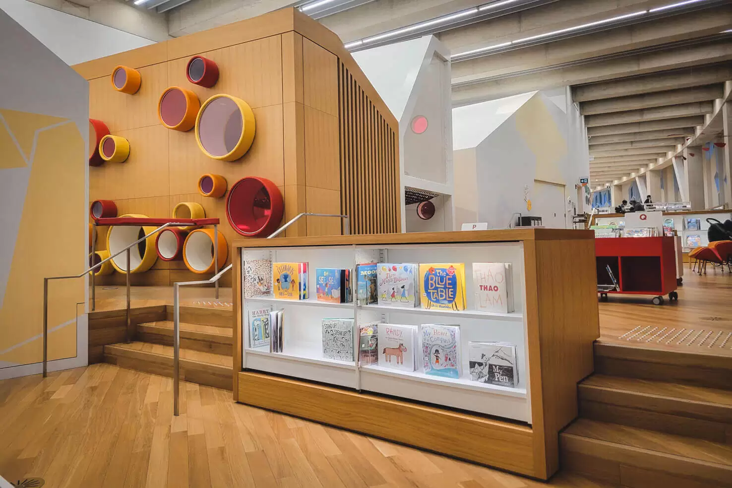 The full-body play structure with colourful round openings and children's books at Central Library