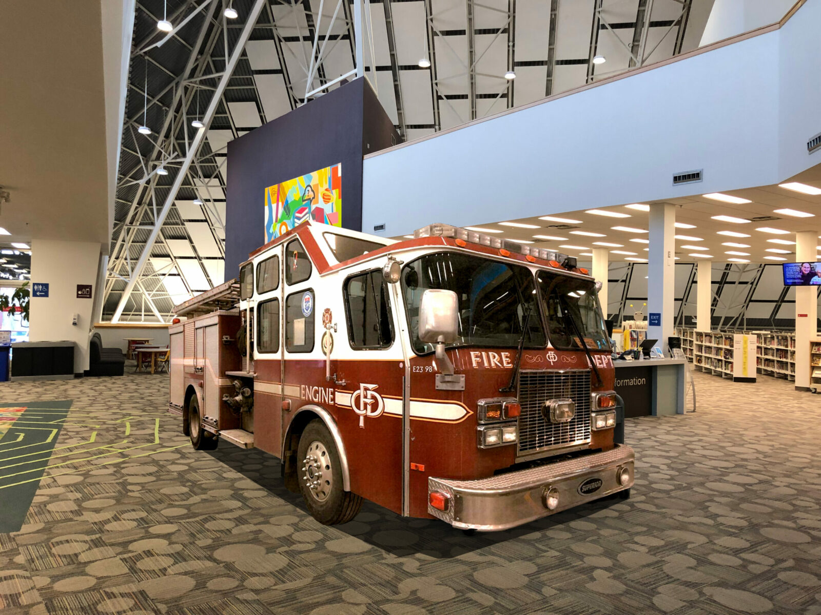 Engine 23, a retired red and white fire engine, displayed inside a library